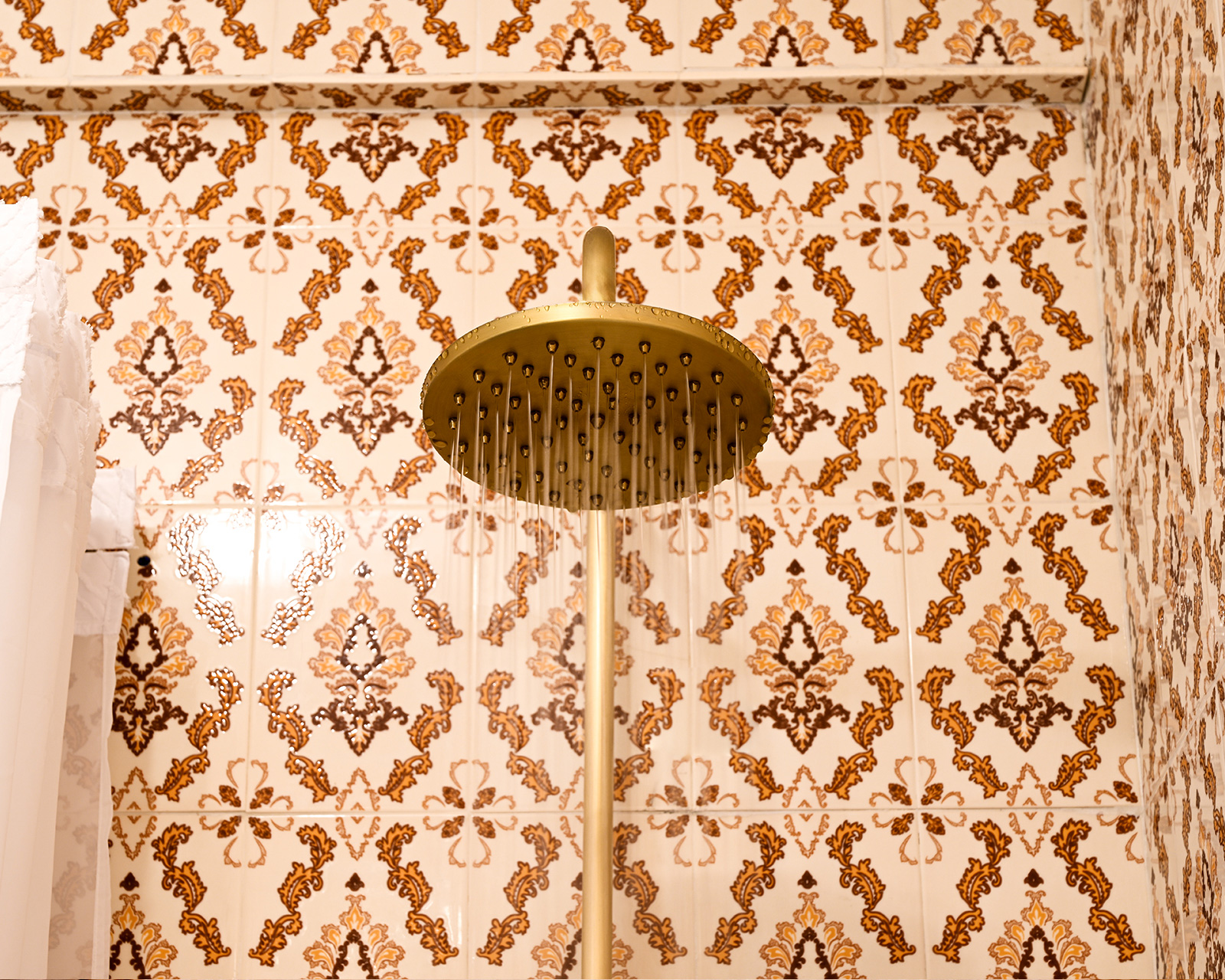 Close-up of vintage-style rain shower head with water streaming in a tiled bathroom at Hacienda Eterna Primavera