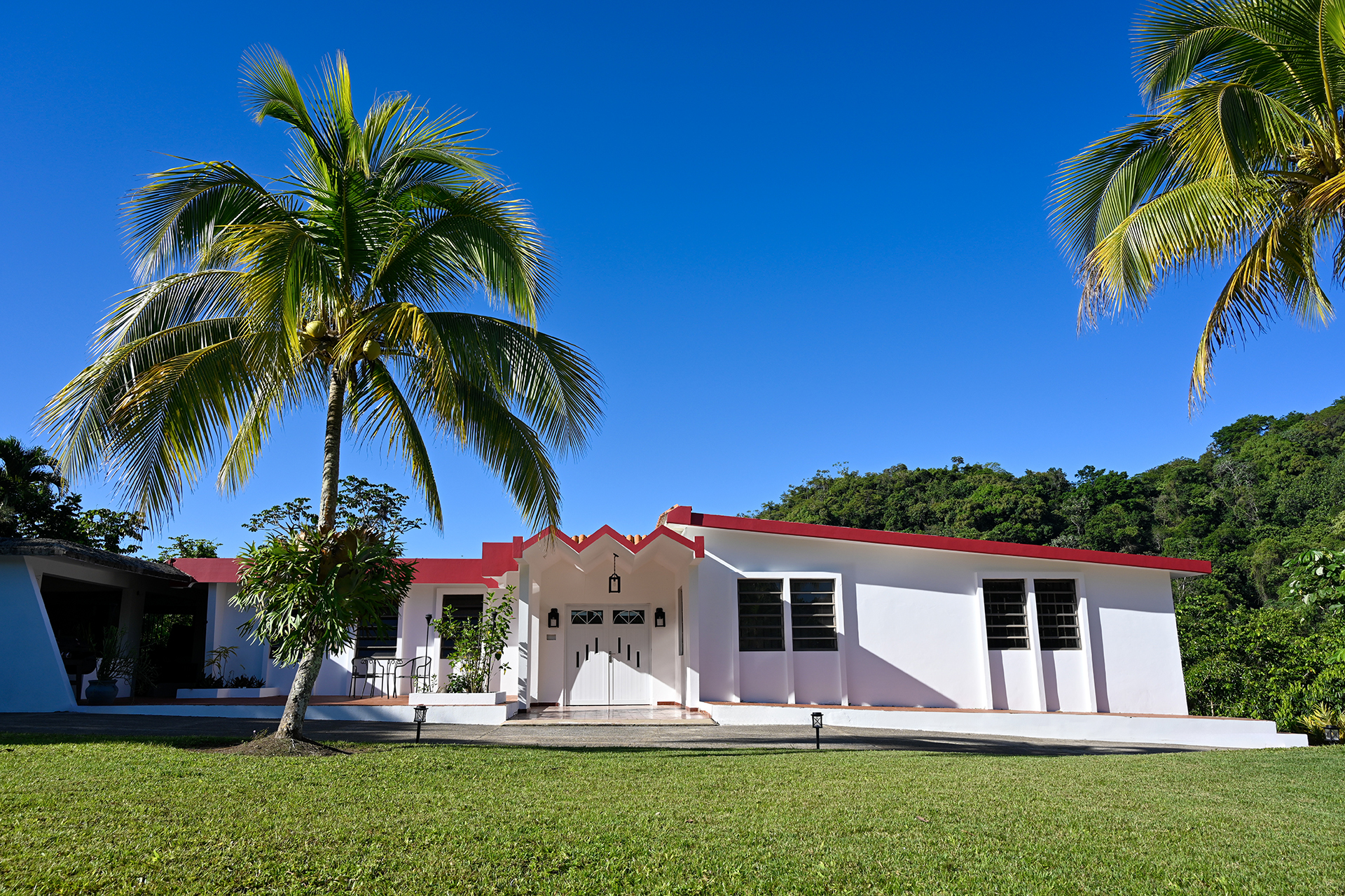 Front view of Hacienda Eterna Primavera under a clear blue sky.