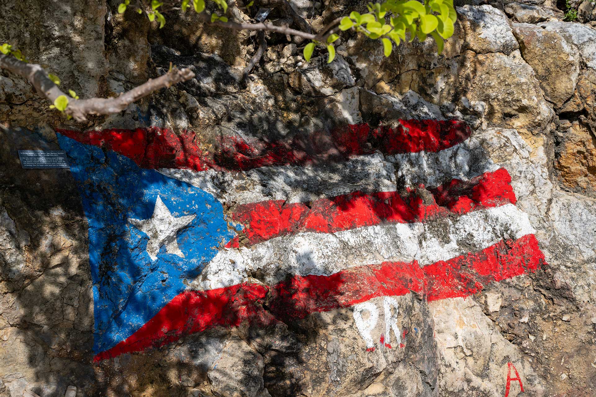 Puerto Rican flag painted on rugged coastal rocks, a proud symbol of the island’s heritage and resilience.