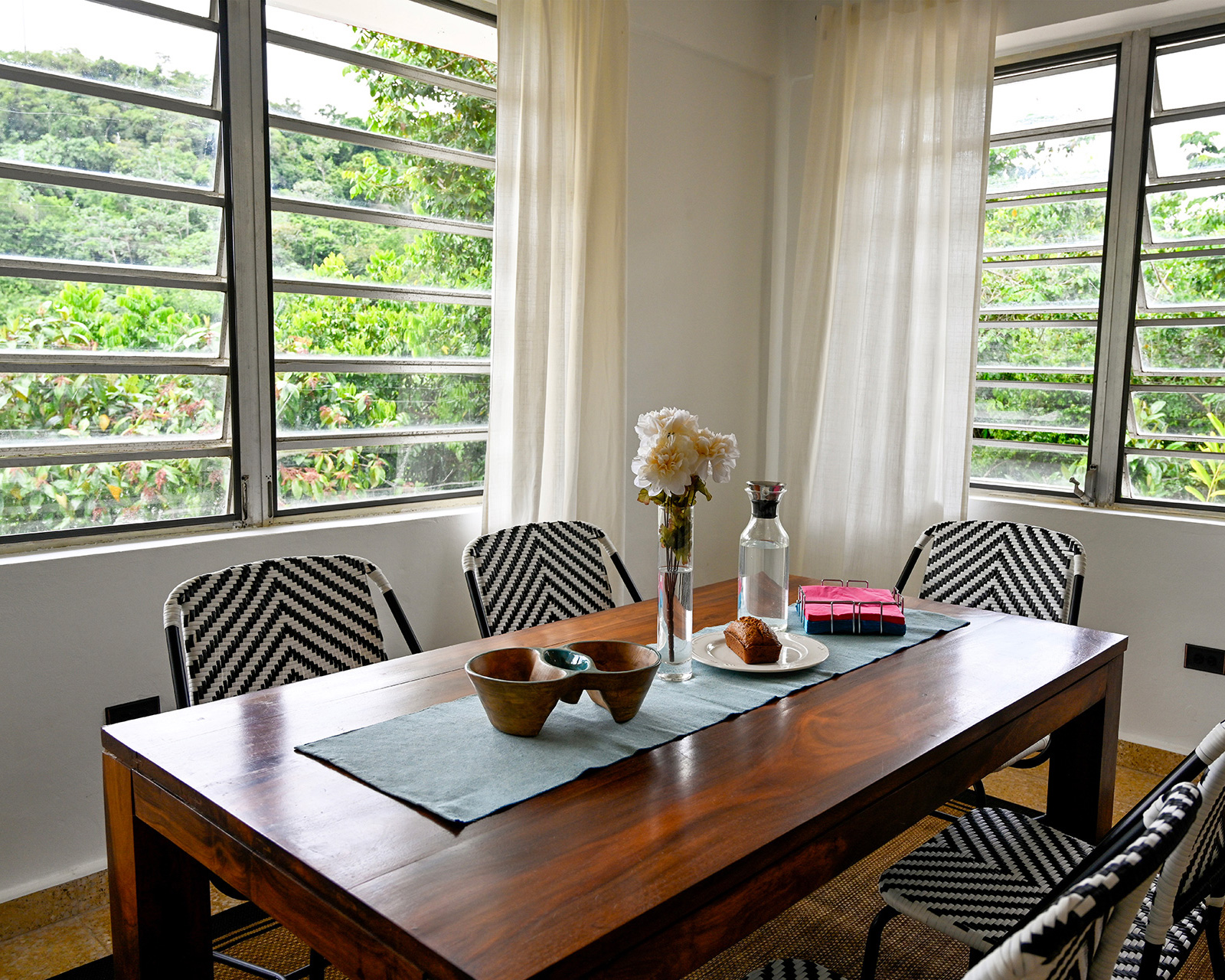 Indoor dining room with mountain views, modern chairs, and breakfast setup at Hacienda Eterna Primavera Puerto Rico
