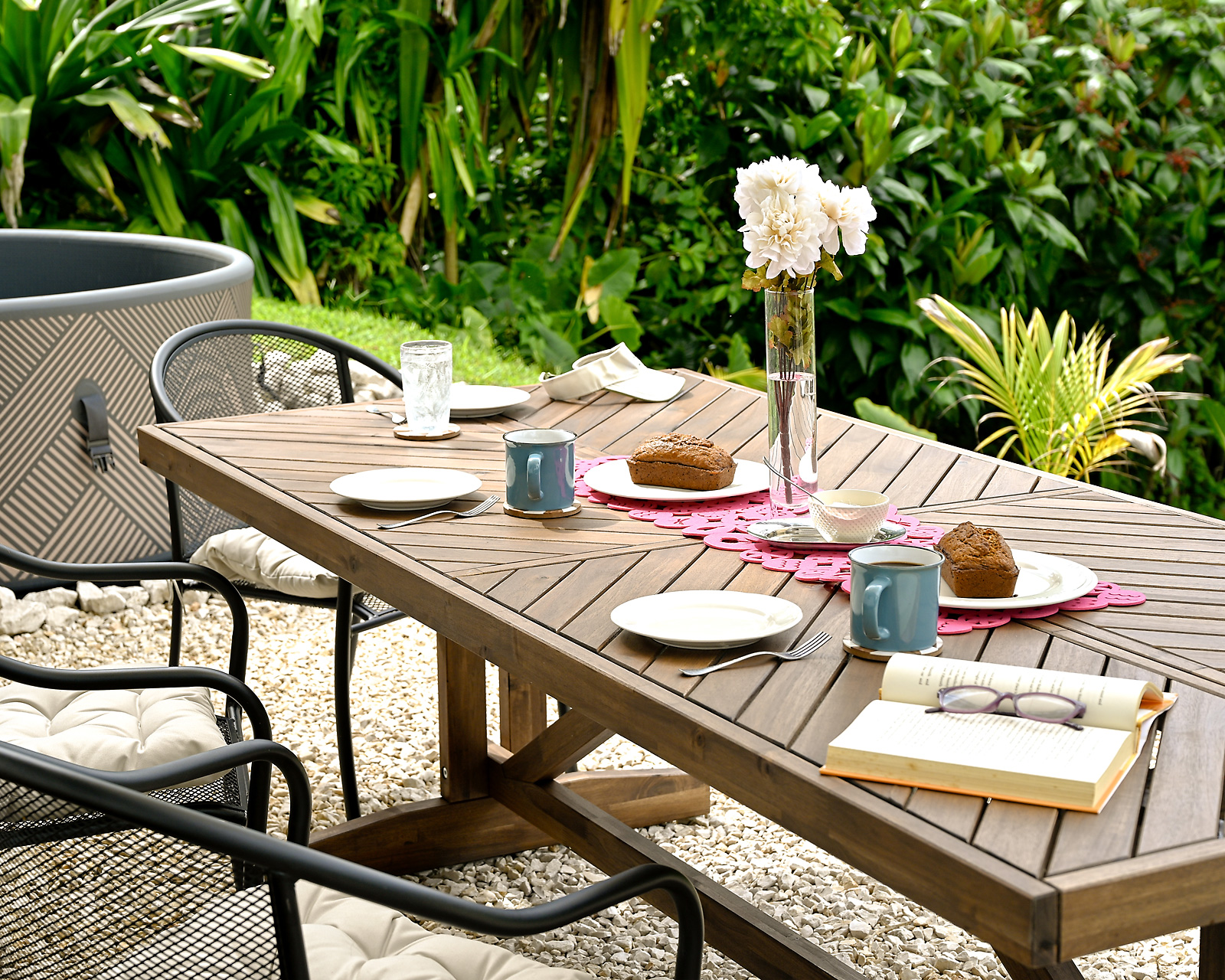 Outdoor dining table with fresh pastries, coffee, and book beside jacuzzi at Hacienda Eterna Primavera Puerto Rico