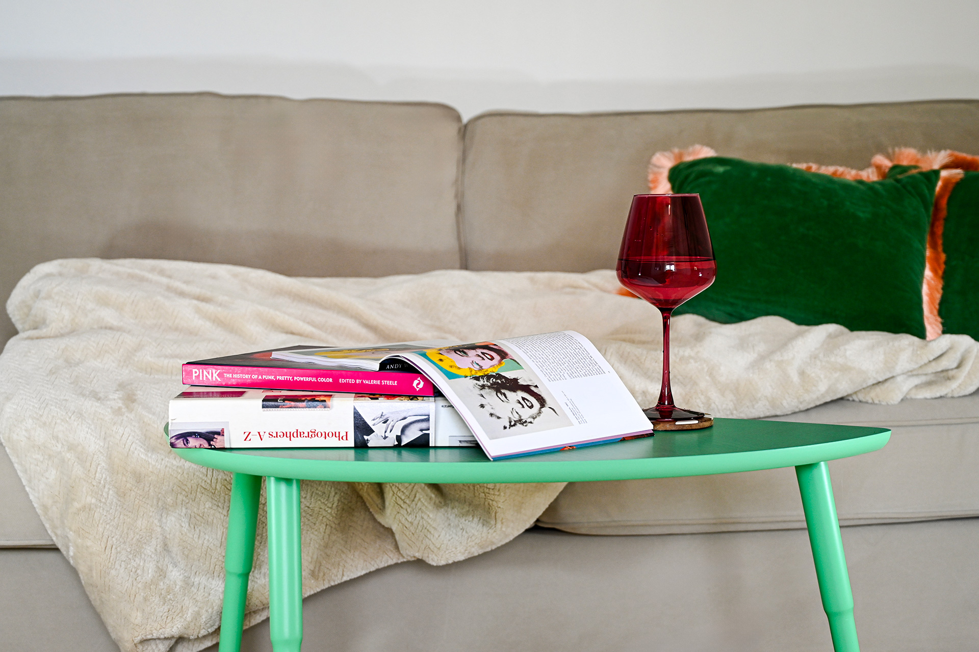 Cozy reading corner with art books, wine glass, and sofa at Hacienda Eterna Primavera in Puerto Rico