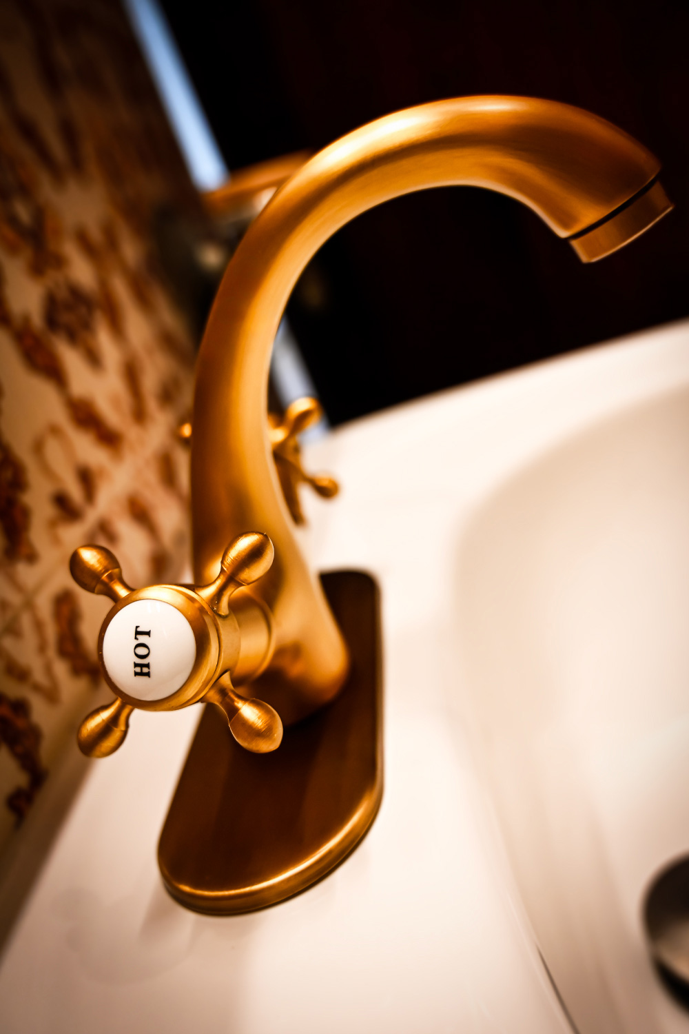 Close-up of a vintage brass bathroom faucet with warm lighting