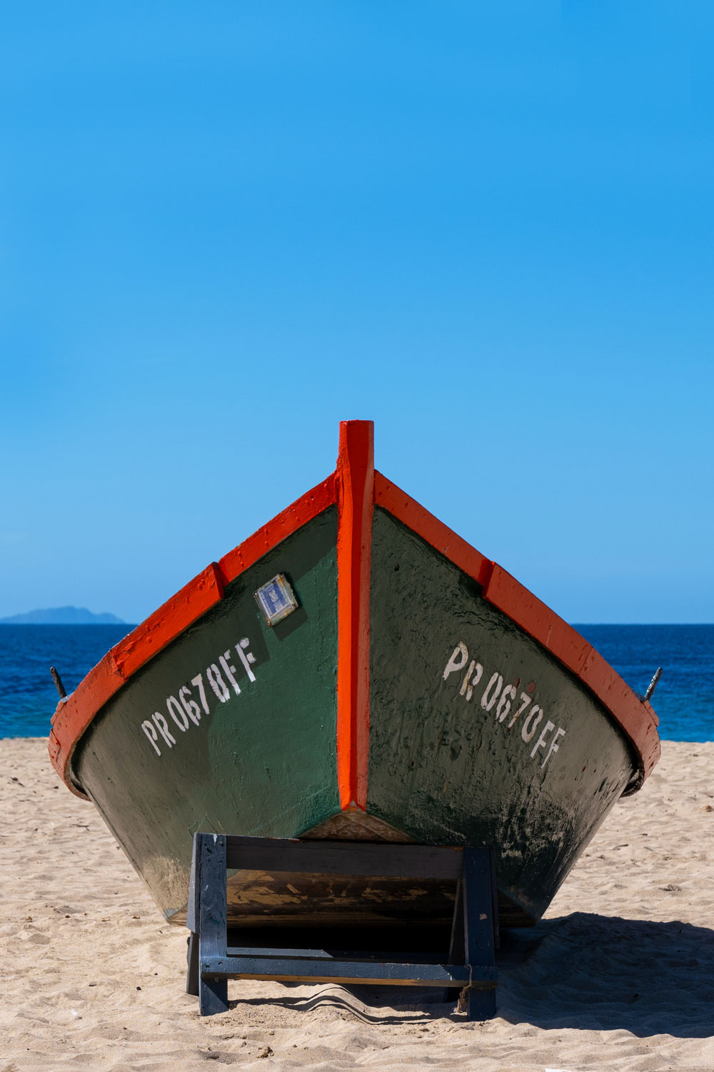 Traditional Puerto Rican fishing boat on sandy beach with bright blue sky
