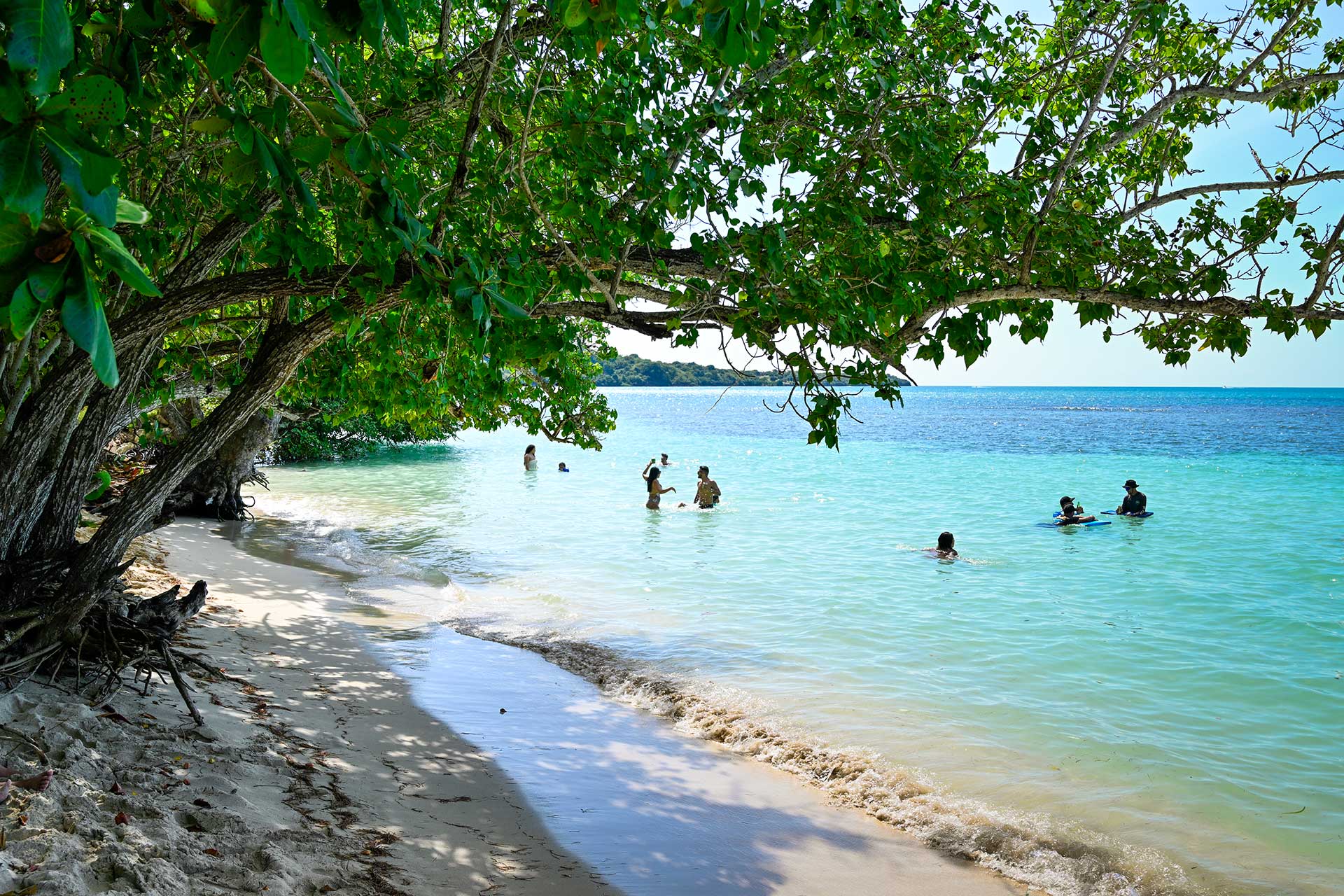 Visitors enjoying the shallow, calm waters at Playa Buyé in Cabo Rojo during a relaxed west coast beach day in Puerto Rico