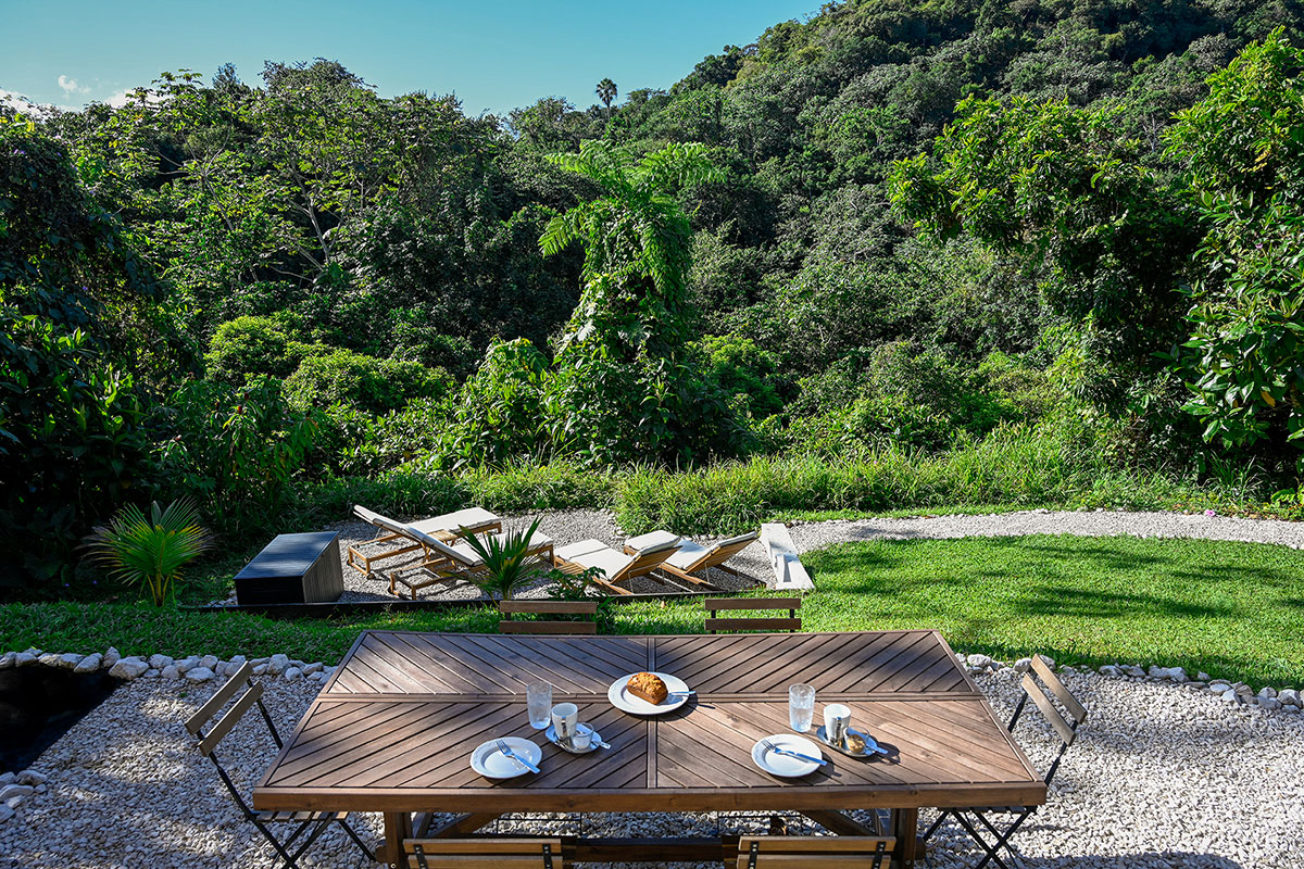 Outdoor table with coffee in the garden at Hacienda Eterna Primavera, overlooking lush greenery